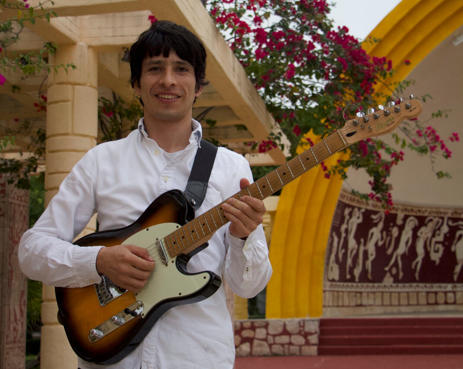 Juan Carlos Grou sonriendo con guitarra en mano